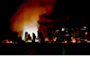 A night view of the Manhattan skyline shows the smoke and glow replacing the once distinctive outline of the landmark twin towers.