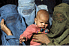 An Afghan woman holds a baby as she waits for humanitarian
aid to be distributed in central Kabul, November 24, 2001.